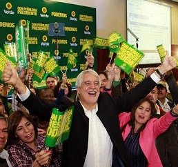Fotos de Enrique Peñalosa alzando los brazos y rodeado de muchas personas con banderas de su campaña.