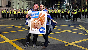 Ciudadanos escoceses a favor de la independencia de Escocia en la ciudad de Glasgow con una pancarta que dice vote yes